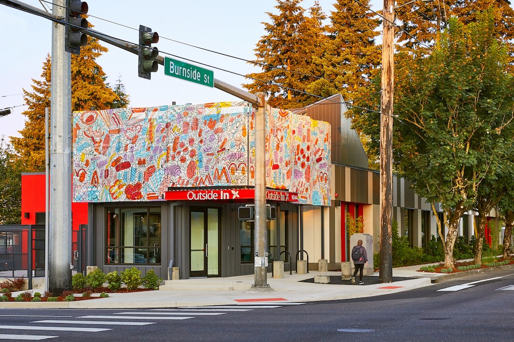 Outside In's east clinic. The building has a colorful mural above the entrance and along the side of the building. The intersection of Burnside and 162nd can be seen.