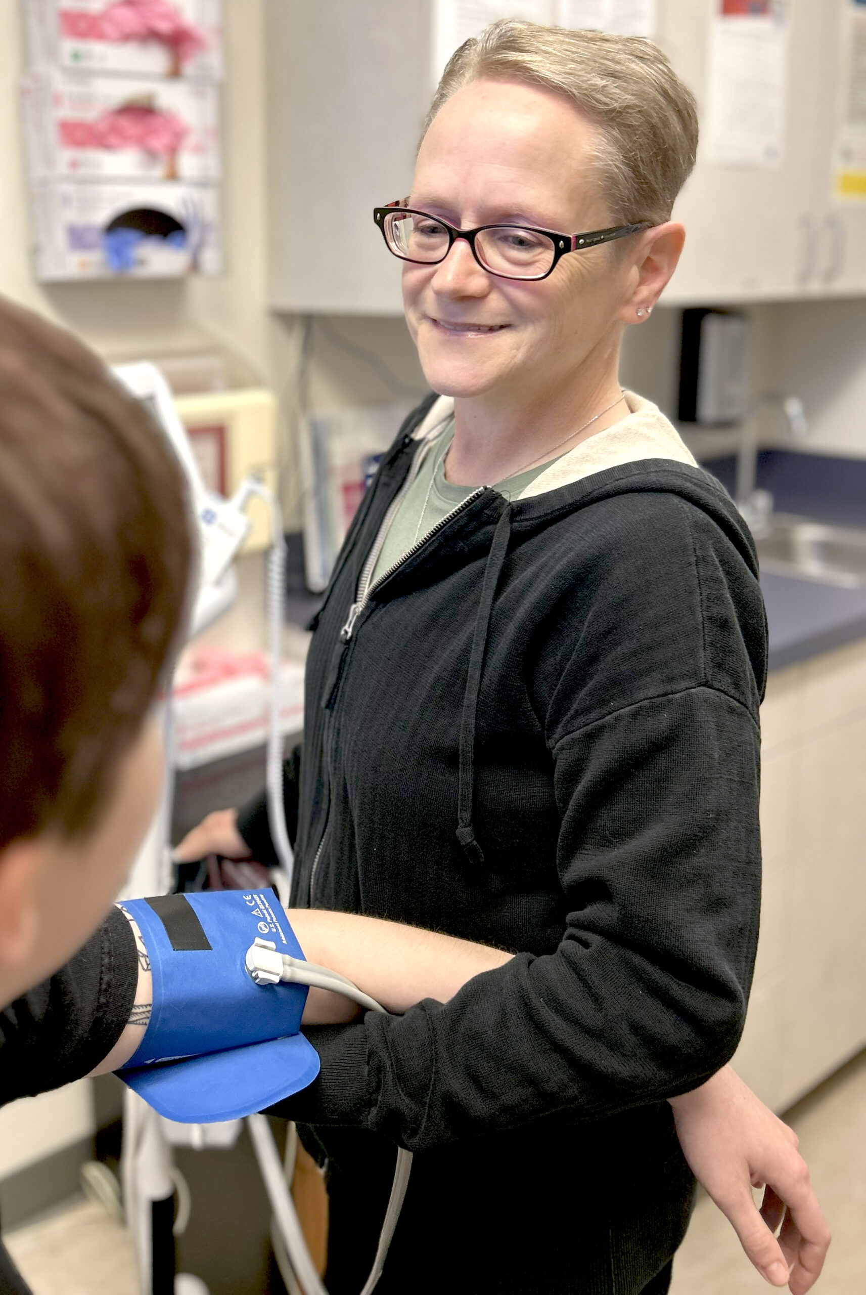 Beverley, a Medical Assistant, checks the blood pressure of a patient at Outside In.